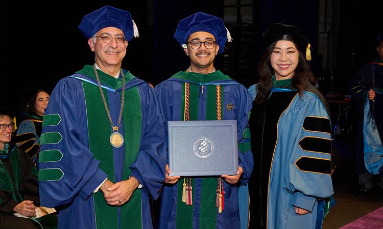 Dean and faculty with student.