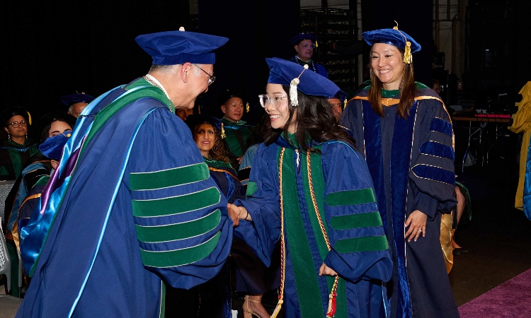 Dean Dalrymple congratulating student.
