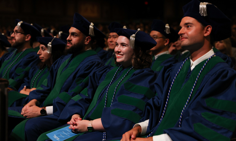 group of graduates listen to commencement speeches