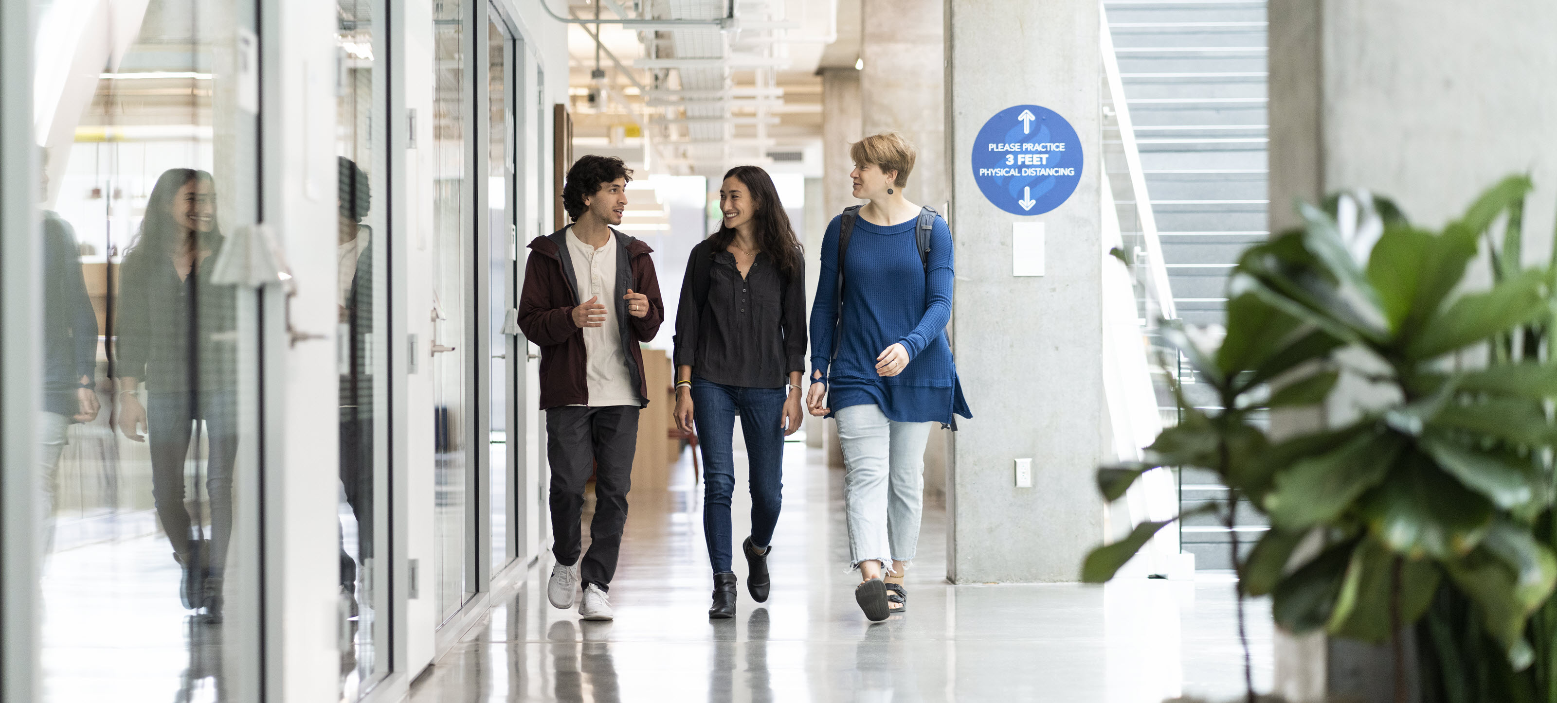 Three students walking through school building.