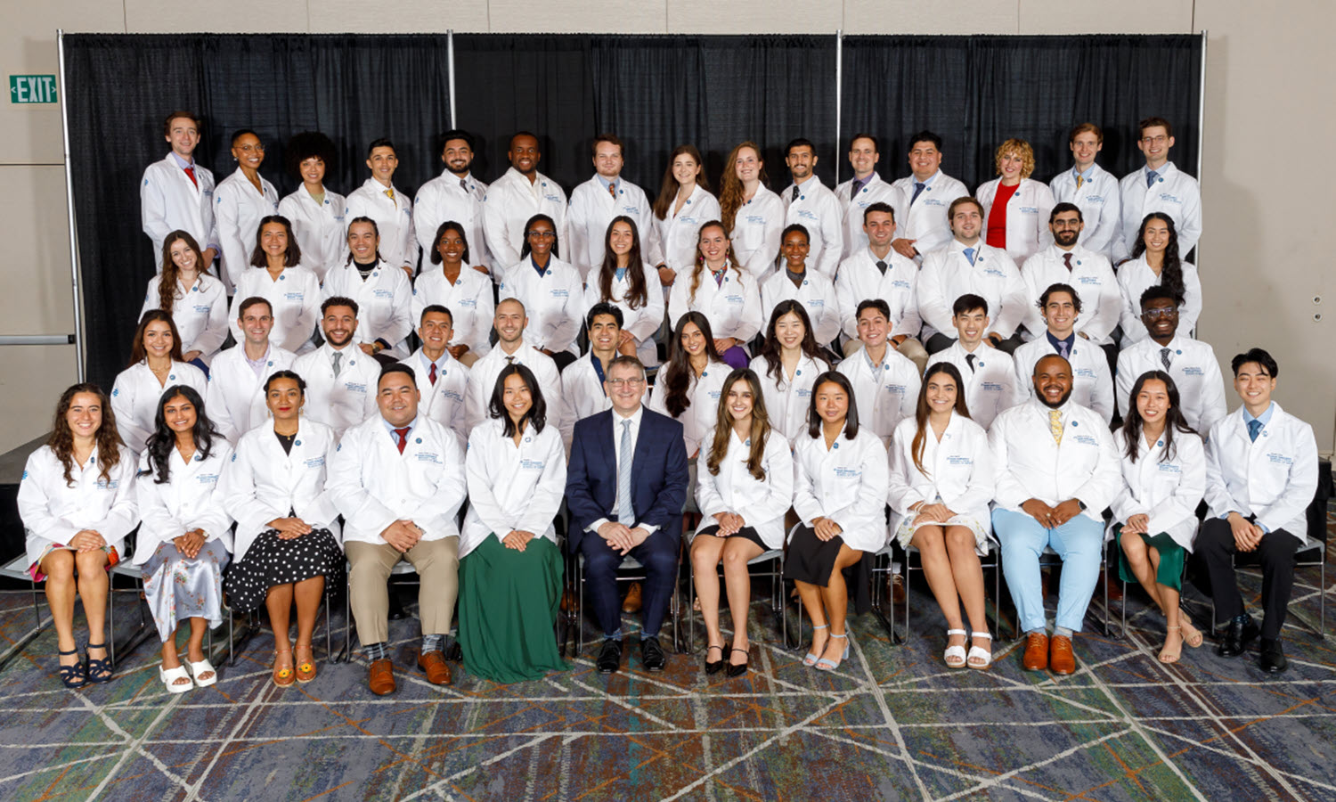 The KPSOM Class of 2027 poses for a class photo with Founding Dean and CEO Mark Schuster.