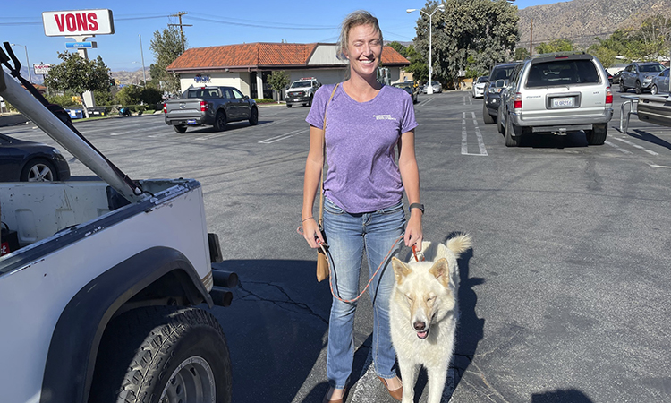 Dr. Ludwig poses with her brace/mobility service dog, Riley.