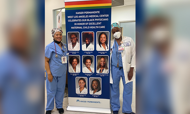Dr. La Tanya Hines (at right), KPSOM Faculty Member and Kaiser Permanente West Los Angeles Medical Center Obstetrics and Gynecology physician, and her colleague Kim Davis, CNM, are flanked by a banner celebrating the medical center’s Black physicians who provide excellent maternal healthcare