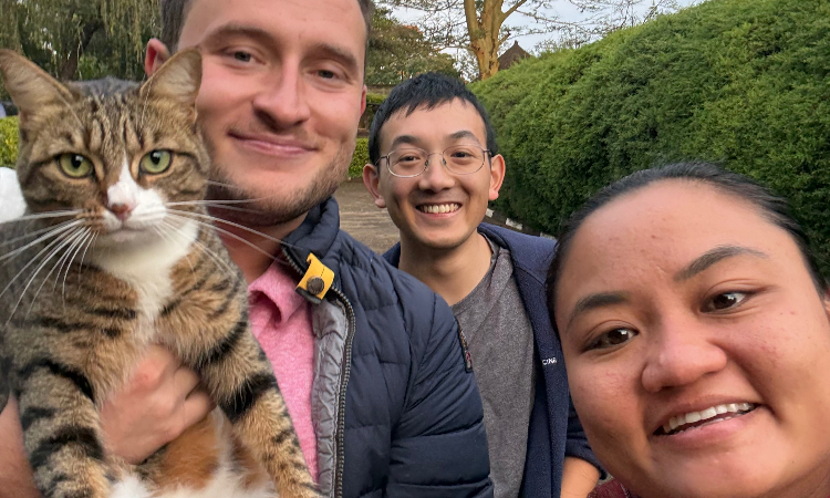 Left to right: Students Sebastian Hurtado, Brandon Chia, and Karina Feliciano at Moi Teaching and Referral Hospital with Embe, the hospital’s resident feline.