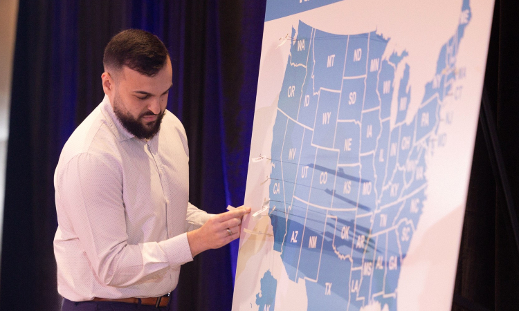 KPSOM student Michael Hanna pins the location of his residency match on a map of the United States, in a tradition observed on Match Day by many medical schools.