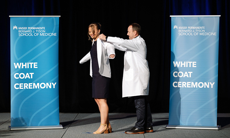 KPSOM student Cassie Collins Santana, a member of the Class of 2028, receives her White Coat onstage during the ceremony.